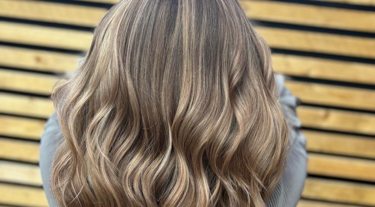 Elegant wavy hairstyle at Hair by Sian Charlton, Cardiff, Wales, GB, showcasing glossy, layered blonde locks.
