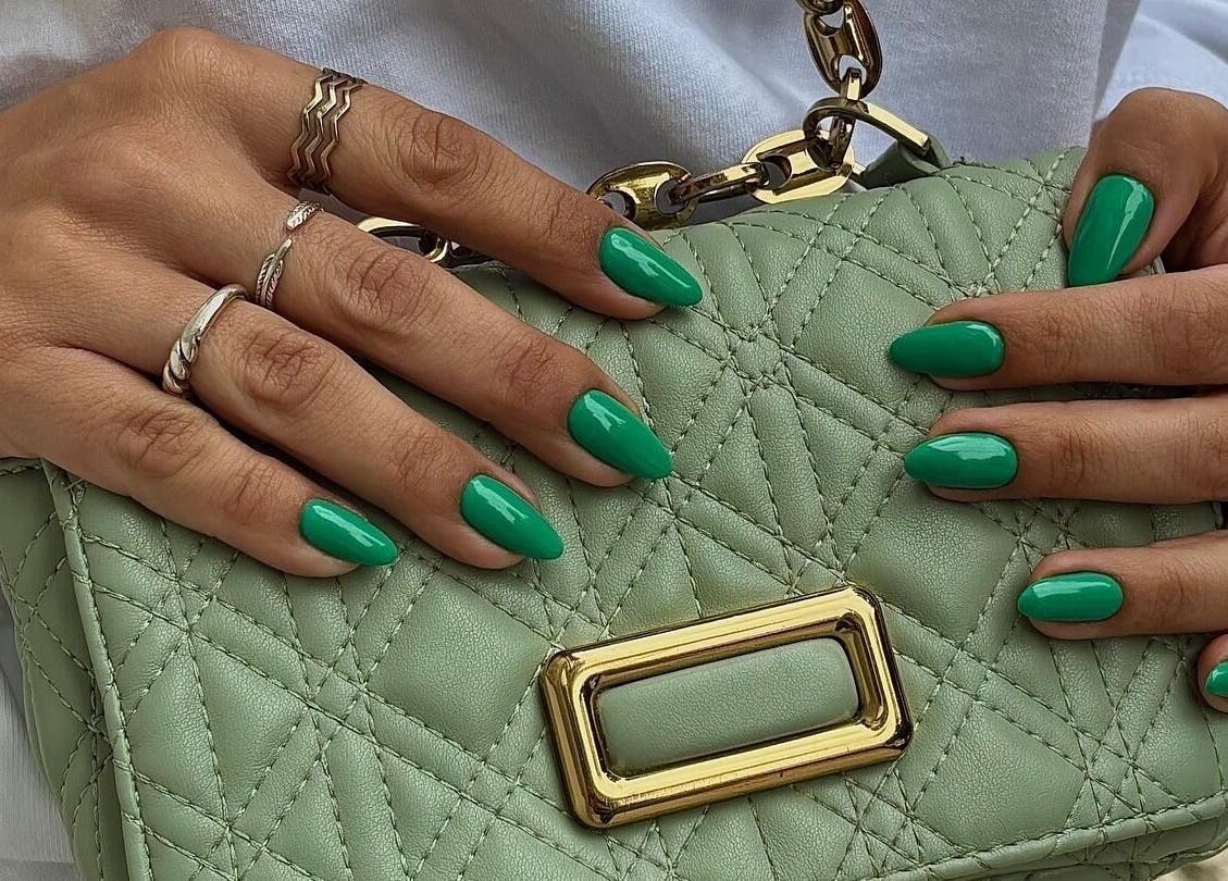 Unhas verdes elegantes no Minha Flor Nails & Spa, Lisboa, Lisboa, PT, segurando bolsa de couro verde.