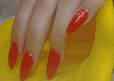 Vibrant red nails at Diamond Nails (Perth CBD), Perth, Western Australia, AU, displayed on yellow fabric.