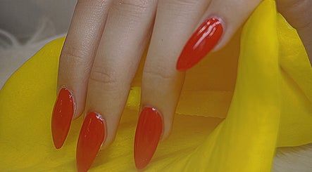 Vibrant red manicured nails on yellow fabric at Diamond Nails (Perth CBD), Perth, Western Australia, AU.