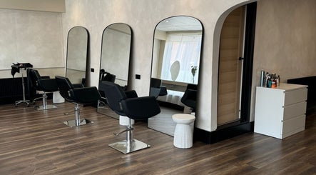 Modern salon interior at Robyn Strong Makeup, Nottingham, England, GB, featuring sleek black chairs and large mirrors.