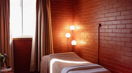 Cozy massage room at Just Massage, Diamond Creek, Victoria, AU with warm lighting and calming decor.