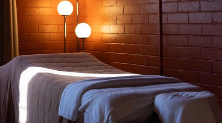 Serene massage room at Just Massage, Diamond Creek, Victoria, AU with warm lighting and comfortable table.