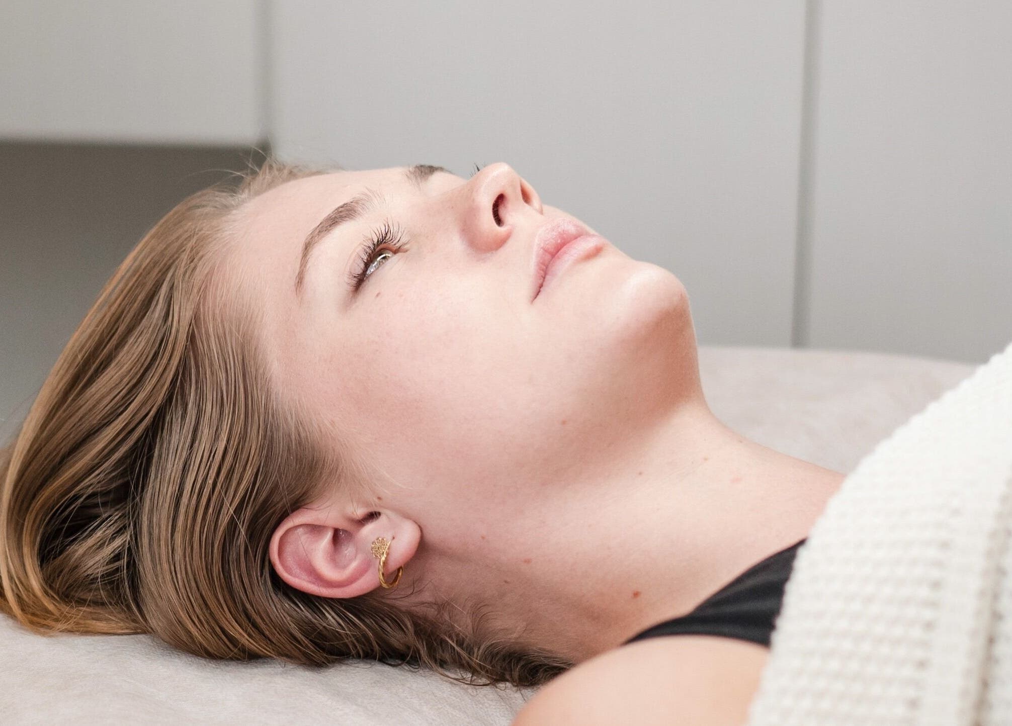 Relaxed woman receiving treatment at The Dermal Haven, Bentleigh East, Victoria, AU.