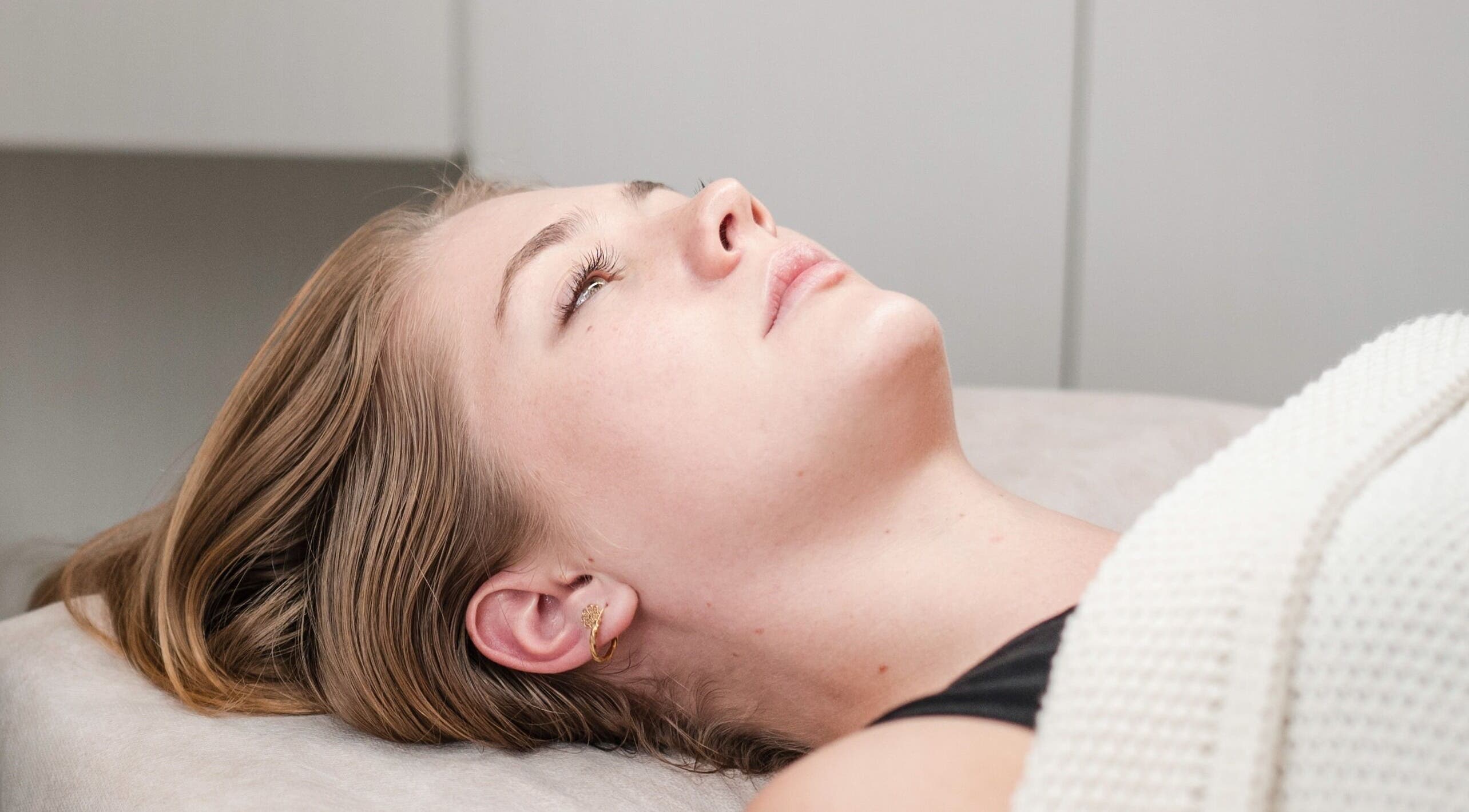 Relaxed woman receiving treatment at The Dermal Haven, Bentleigh East, Victoria, AU.