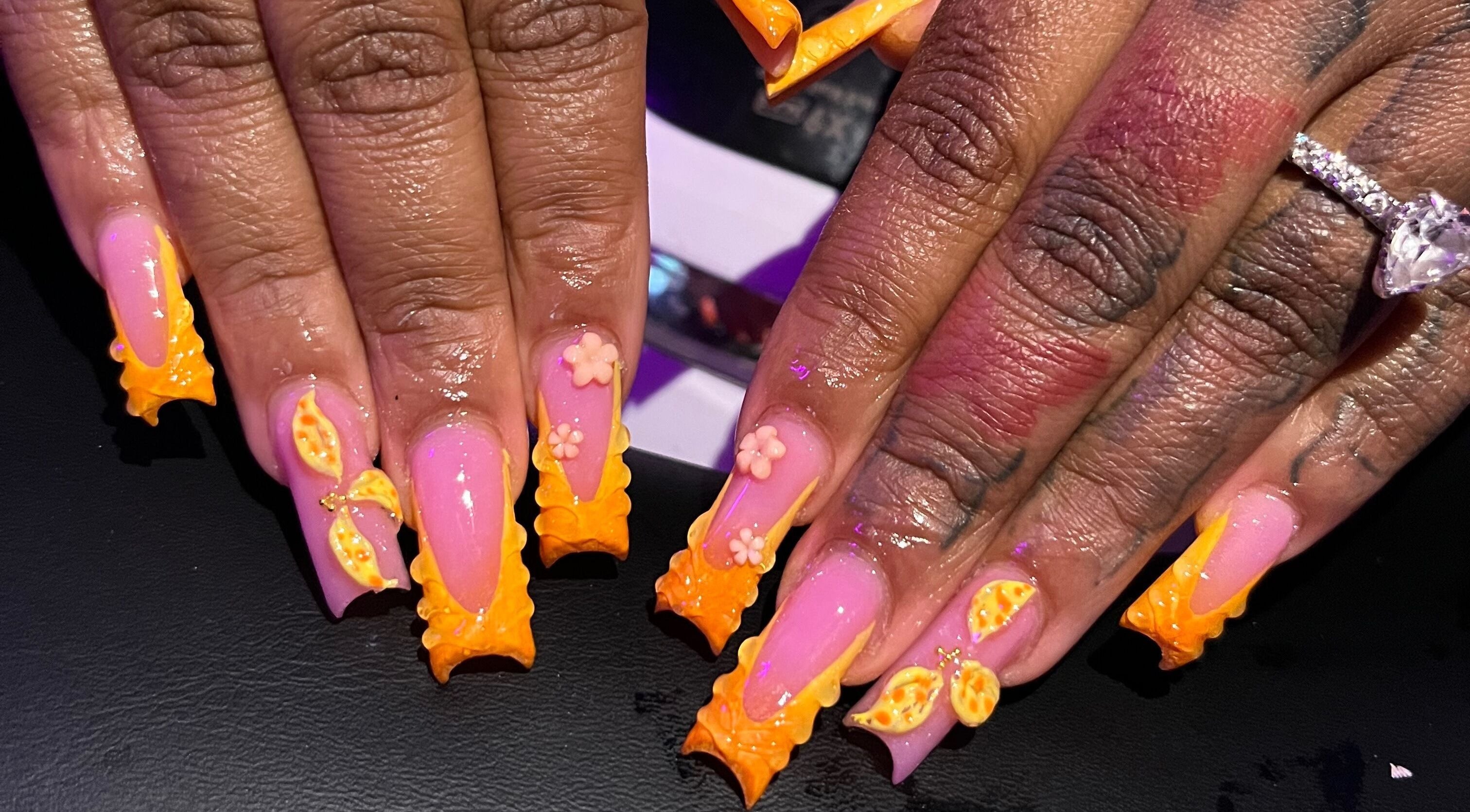 Detailed nail art with orange accents at Visage VERITAS, Troy, New York, US.