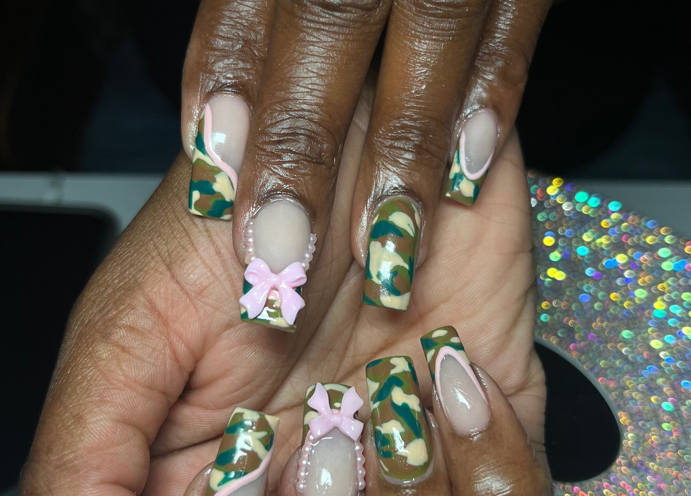 Intricate camouflage nail design with pink bows at Visage VERITAS, Troy, New York, US.
