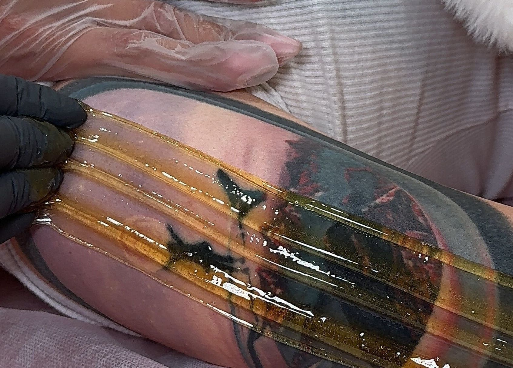 Sugaring treatment on tattooed arm at Sugaring & Waxing by Ervina, Los Angeles, California, US.