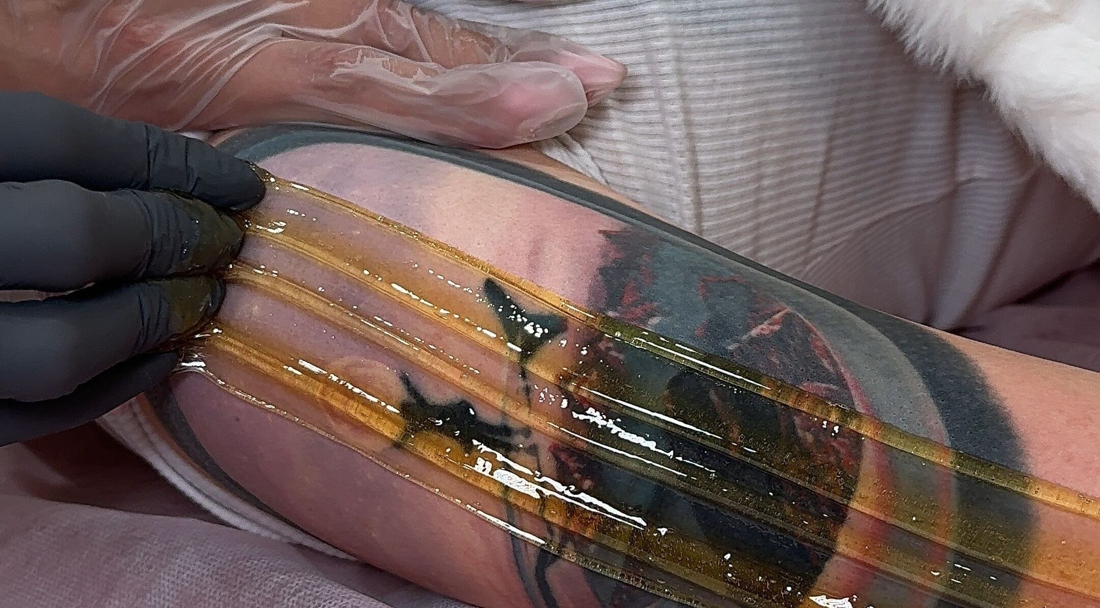 Sugaring treatment on tattooed arm at Sugaring & Waxing by Ervina, Los Angeles, California, US.