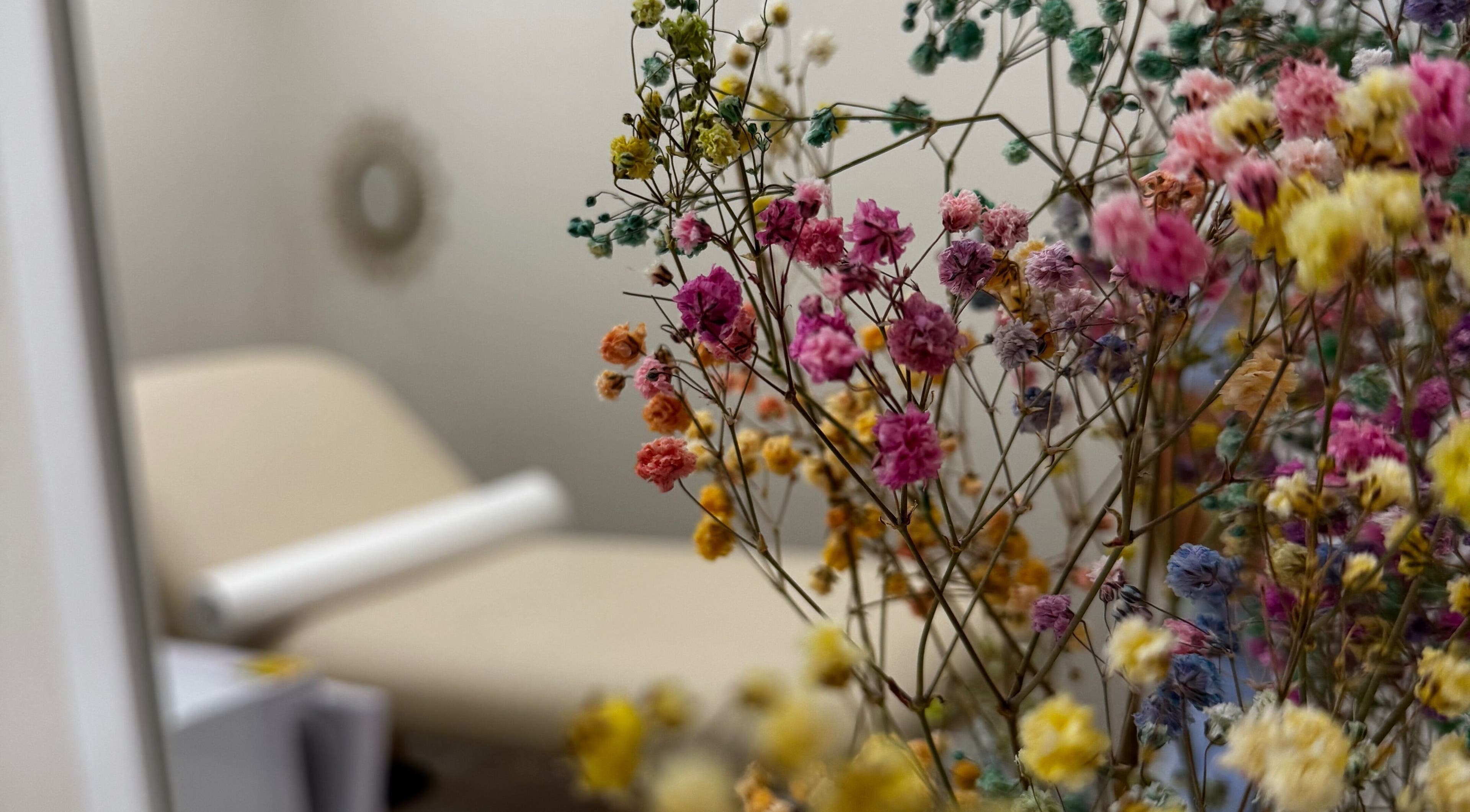 Cozy treatment room with vibrant flowers at Sugaring & Waxing by Ervina, Los Angeles, California, US.
