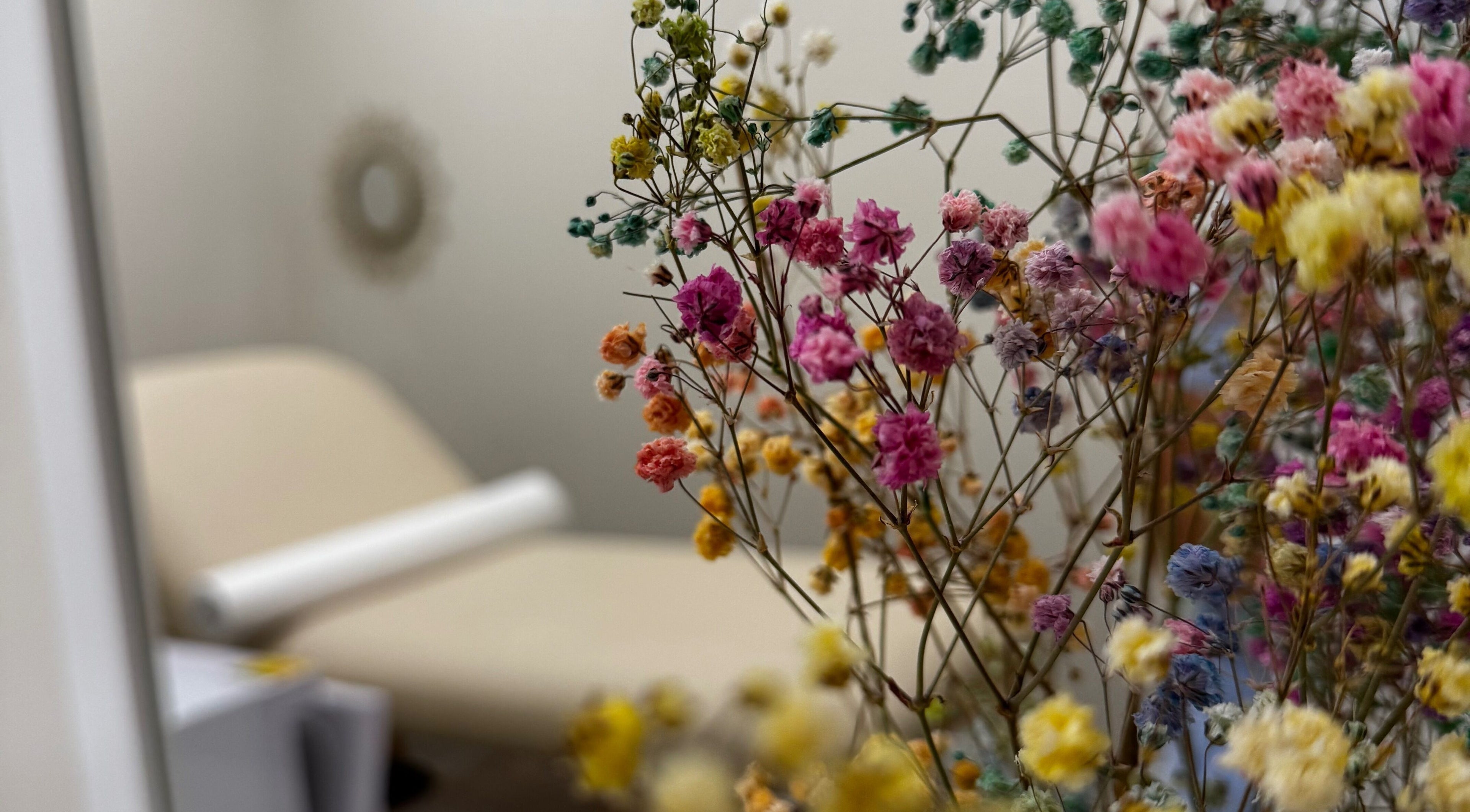Cozy treatment room with vibrant flowers at Sugaring & Waxing by Ervina, Los Angeles, California, US.