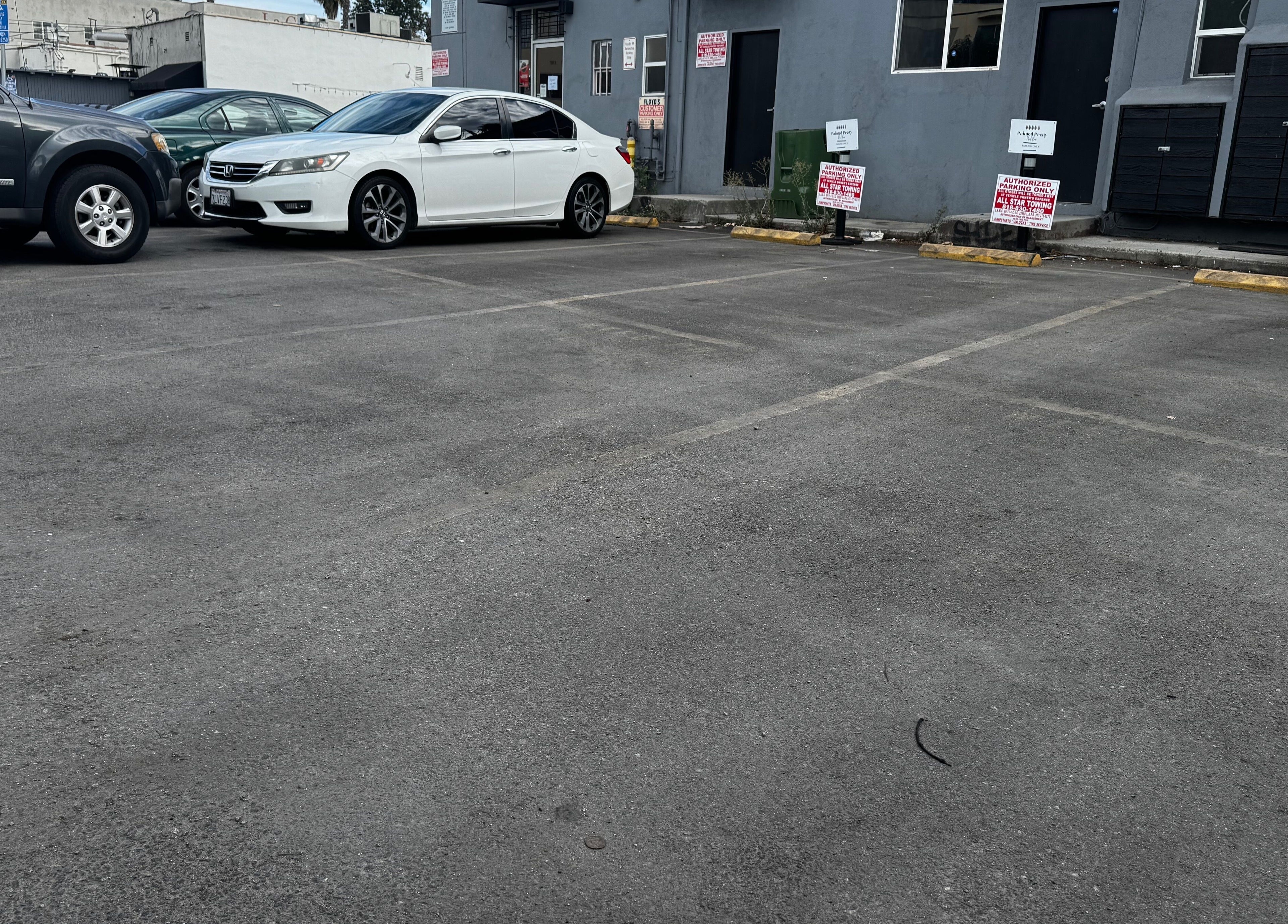 Parking area outside Sugaring & Waxing by Ervina in Los Angeles, California, US with parked cars.