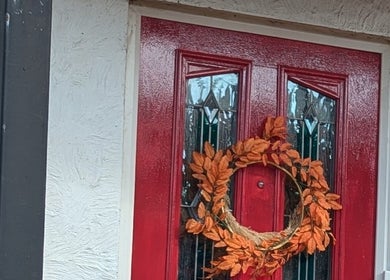 Elegant red door with autumn wreath at Sarah Harris Tattoos, Bishop's Stortford, England, GB.