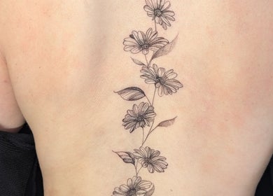 Elegant floral tattoo on back at Sarah Harris Tattoos in Bishop's Stortford, England, GB.