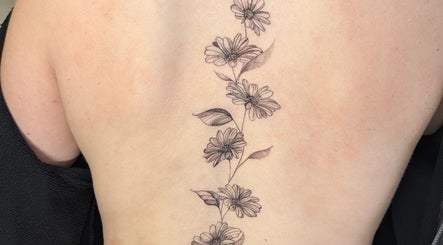 Elegant floral tattoo on back at Sarah Harris Tattoos in Bishop's Stortford, England, GB.