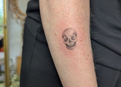 Detailed skull tattoo on forearm at Sarah Harris Tattoos, Bishop's Stortford, England, GB.