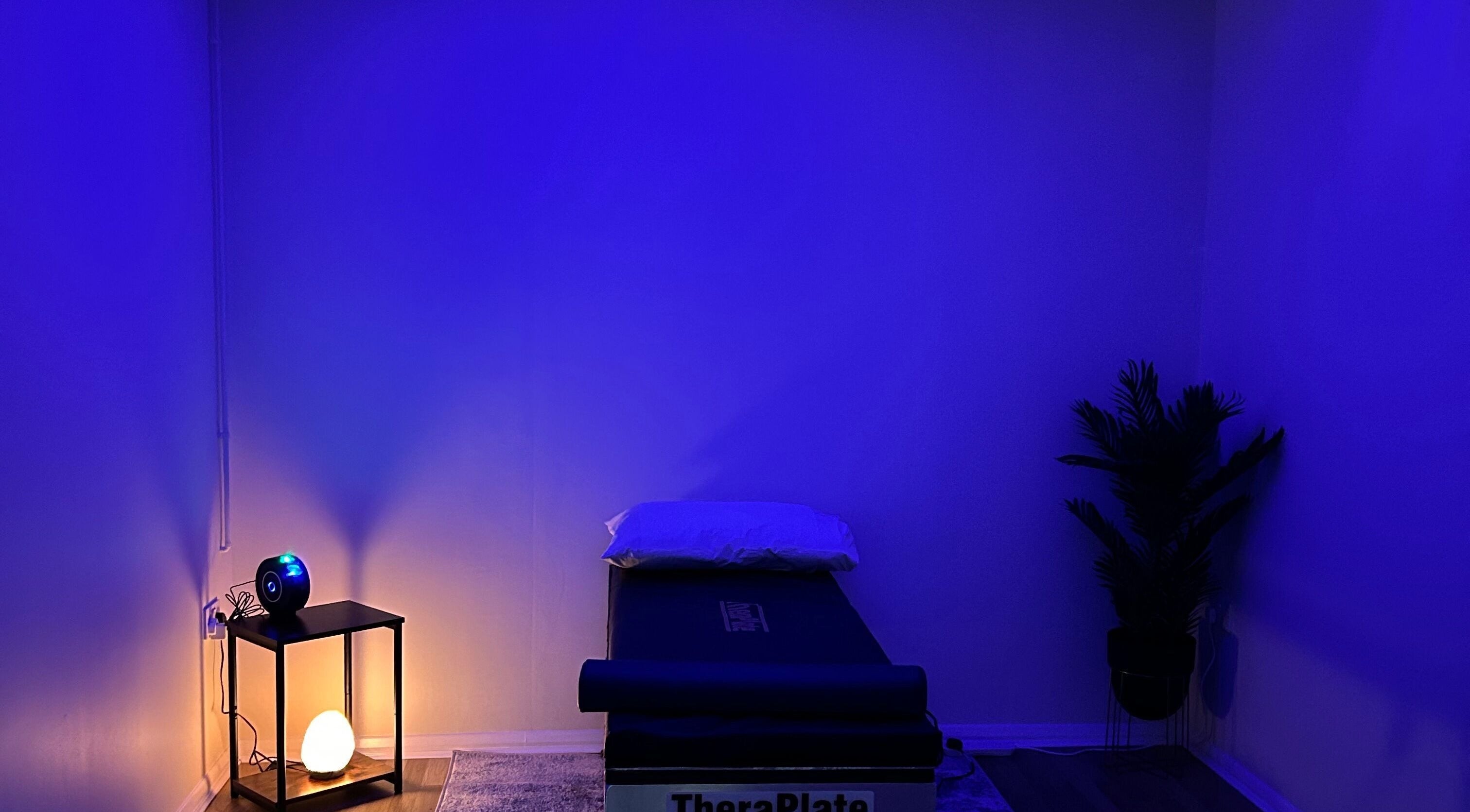 Tranquil wellness room at TheraPlate Kirton, Kirton, England, GB with soft blue lighting and a relaxation table.