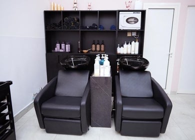 Modern wash stations at Dtangle Hair And Beauty Salon, Dubai, Dubai, AE, showcasing sleek black chairs and products.