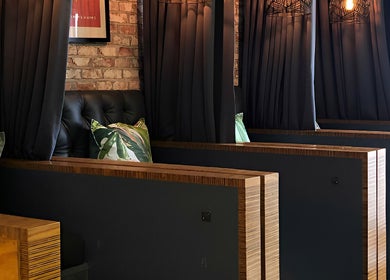 Private, elegant seating in TLC Nail Bar, Germiston, Gauteng, ZA, featuring plush cushions and dark curtains.