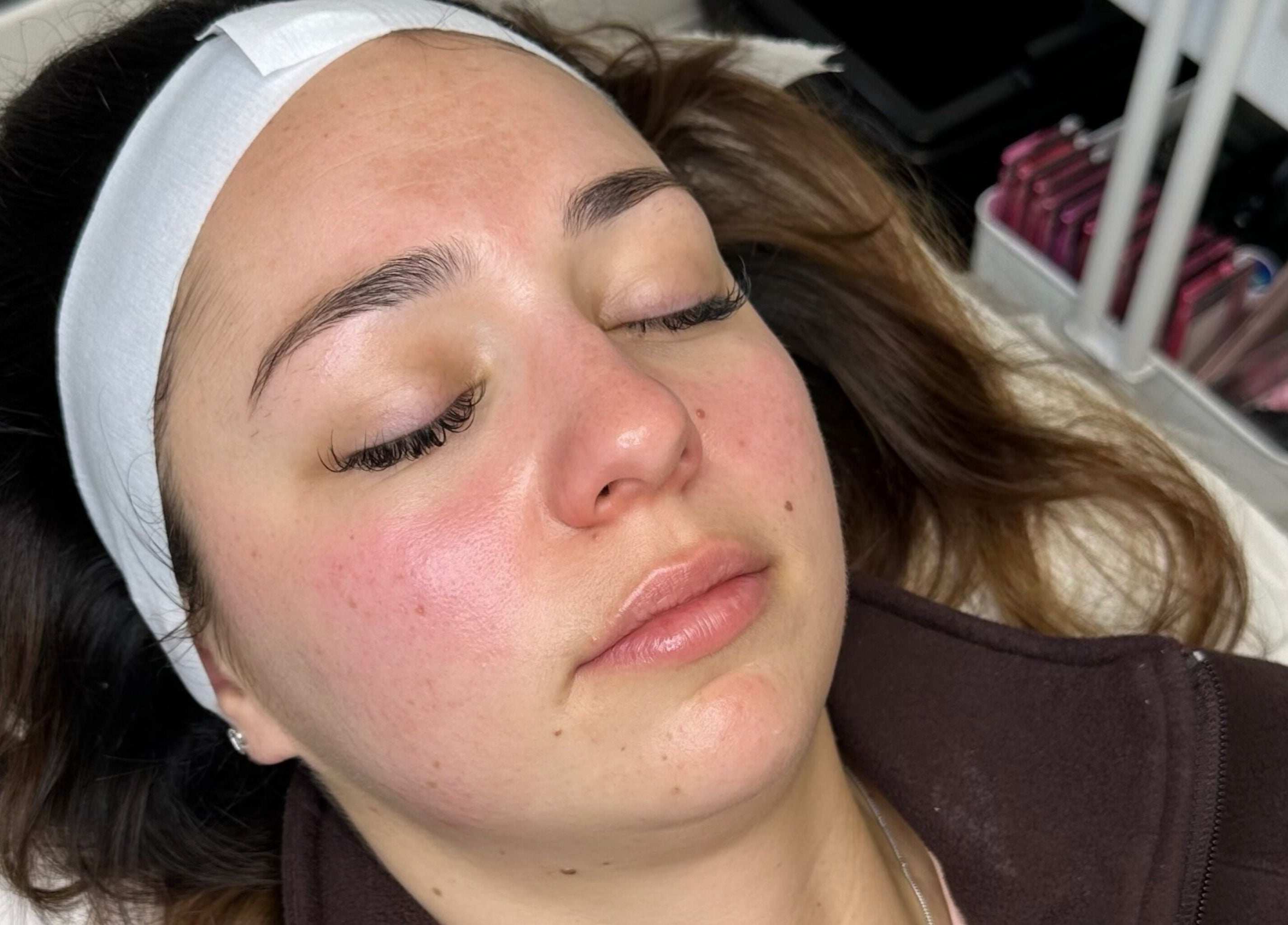 Relaxed client enjoying a facial at Opulent Aesthetics & Beauty, Stevenage, England, GB, enhancing her radiant skin.