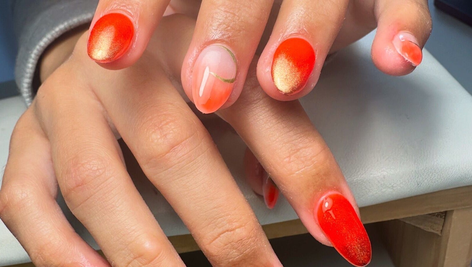 Vibrant orange-red gel nails designed at By Jay Studio, Wigan, England, GB. Perfectly manicured hands.