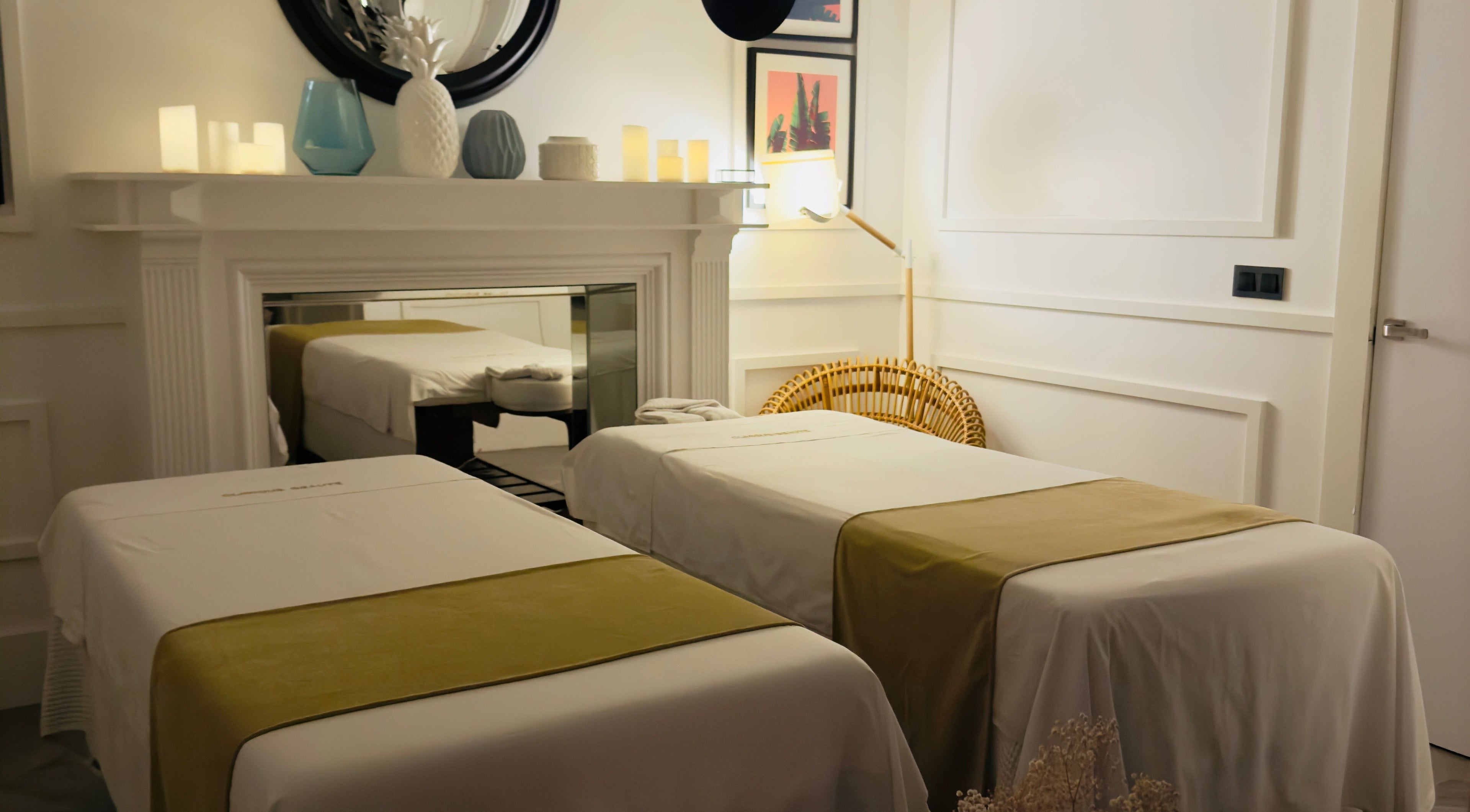 Sala de masaje en Clinique Beauté, Madrid, Comunidad De Madrid, ES con dos camas iluminadas suavemente.