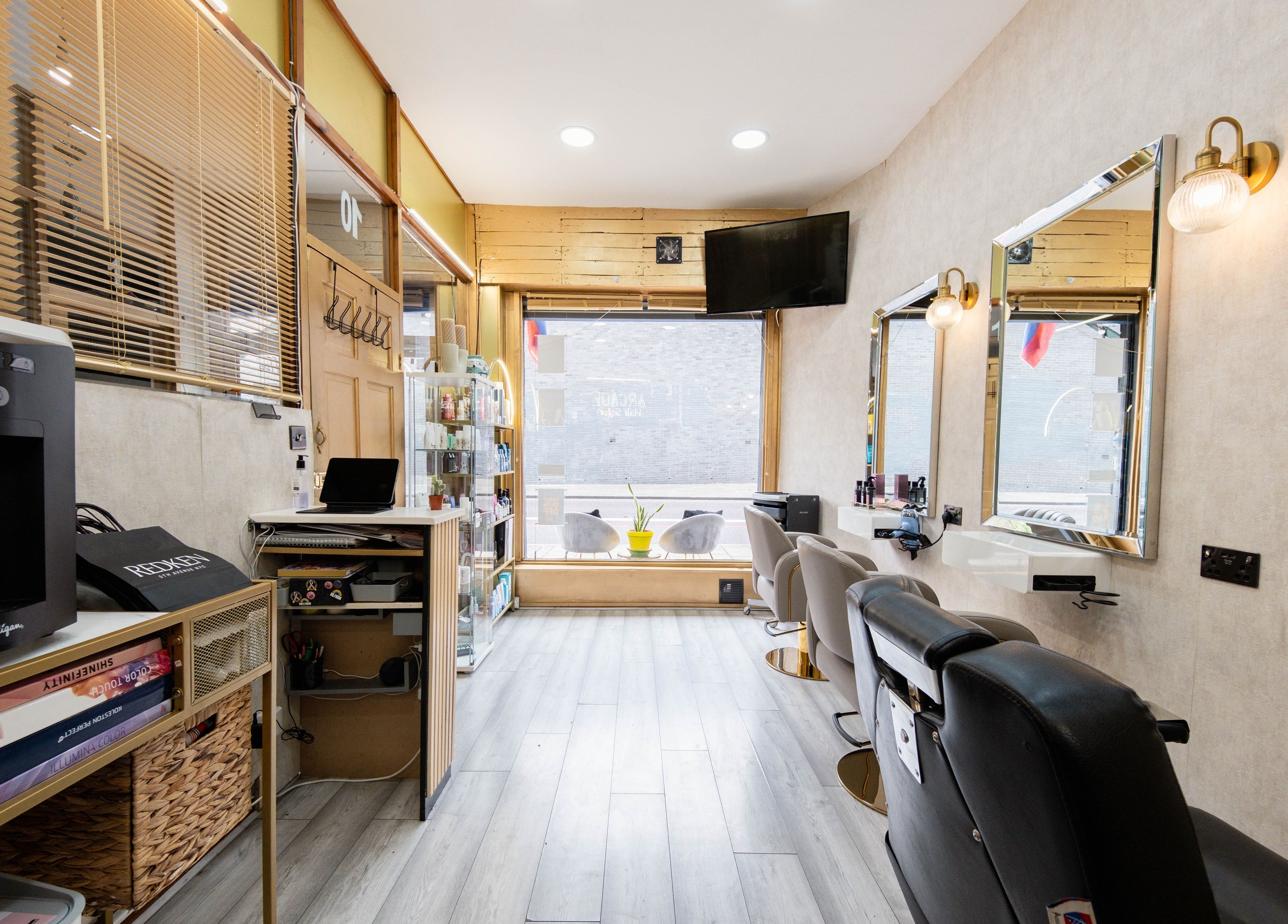 Stylish interior of Arcade Hair Salon in London, England, GB featuring salon chairs, mirrors, and sleek decor.