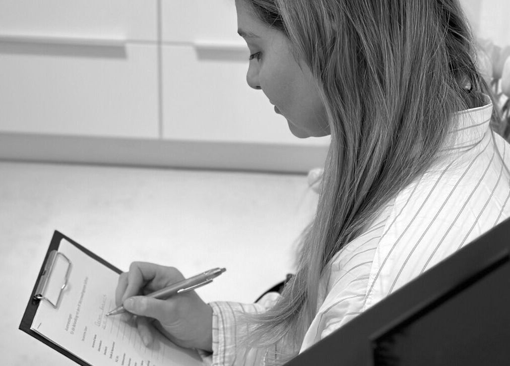 Kundin füllt bei Age-Stop Studio in Düsseldorf ein Formular aus, Nordrhein-westfalen, DE.