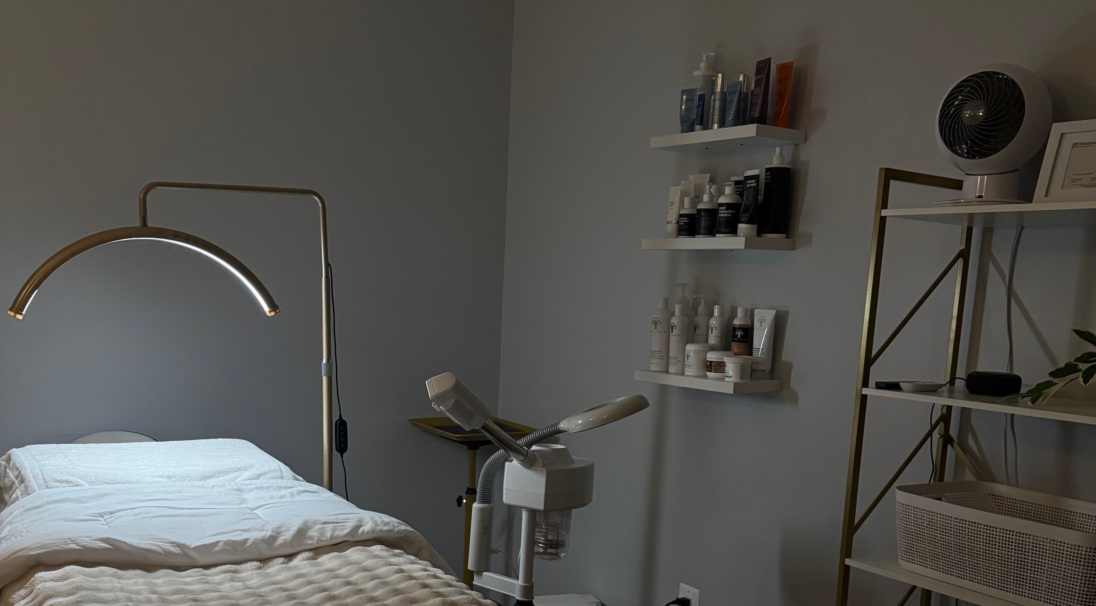 Mina Aesthetics treatment room in North Bethesda, Maryland, US, featuring a cozy bed and skincare products.