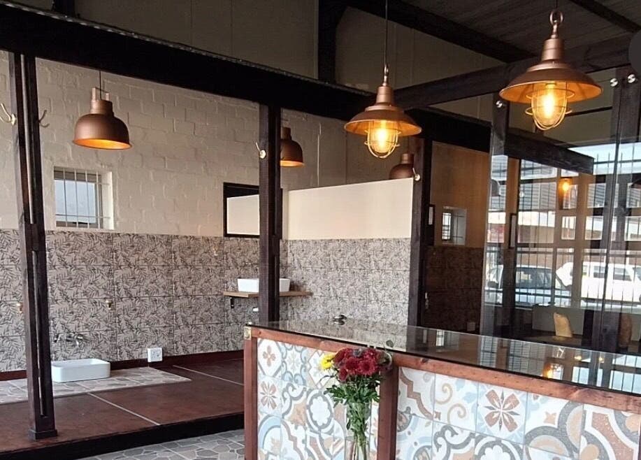 Stylish industrial-chic interior at Neem Studio, Cape Town, Western Cape, ZA with warm lighting and floral decor.