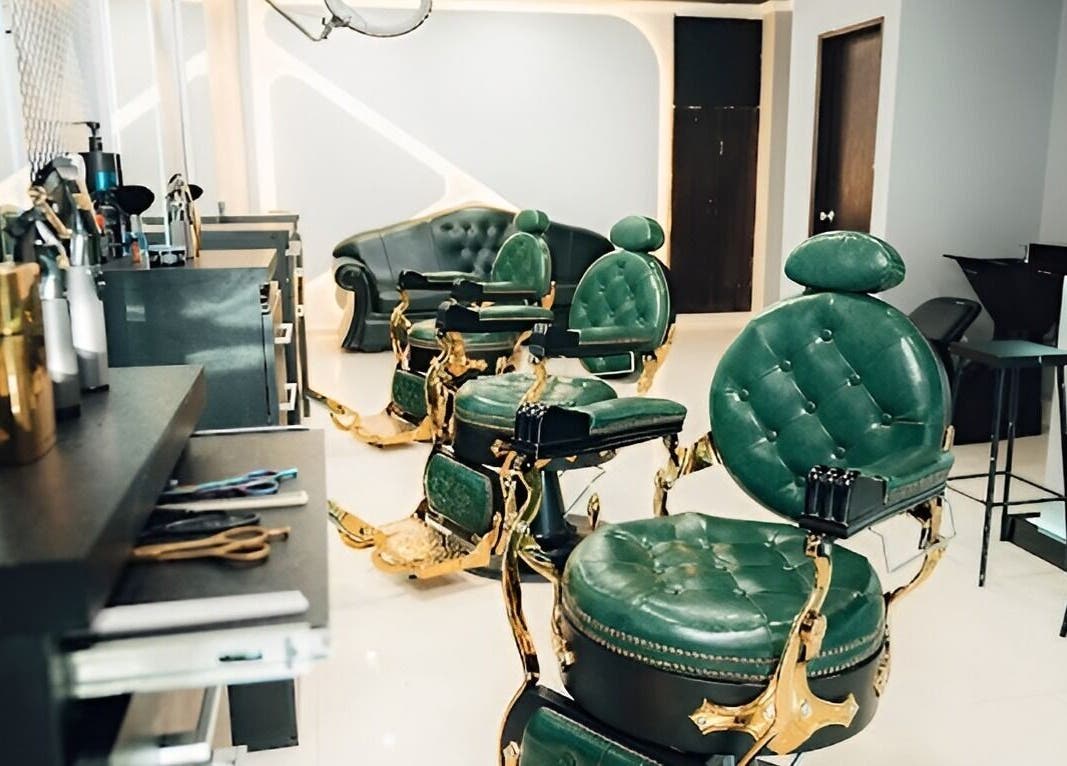Interior elegante de VANGUARD, Santa Cruz De La Sierra, con sillones de estilo verde y dorado.