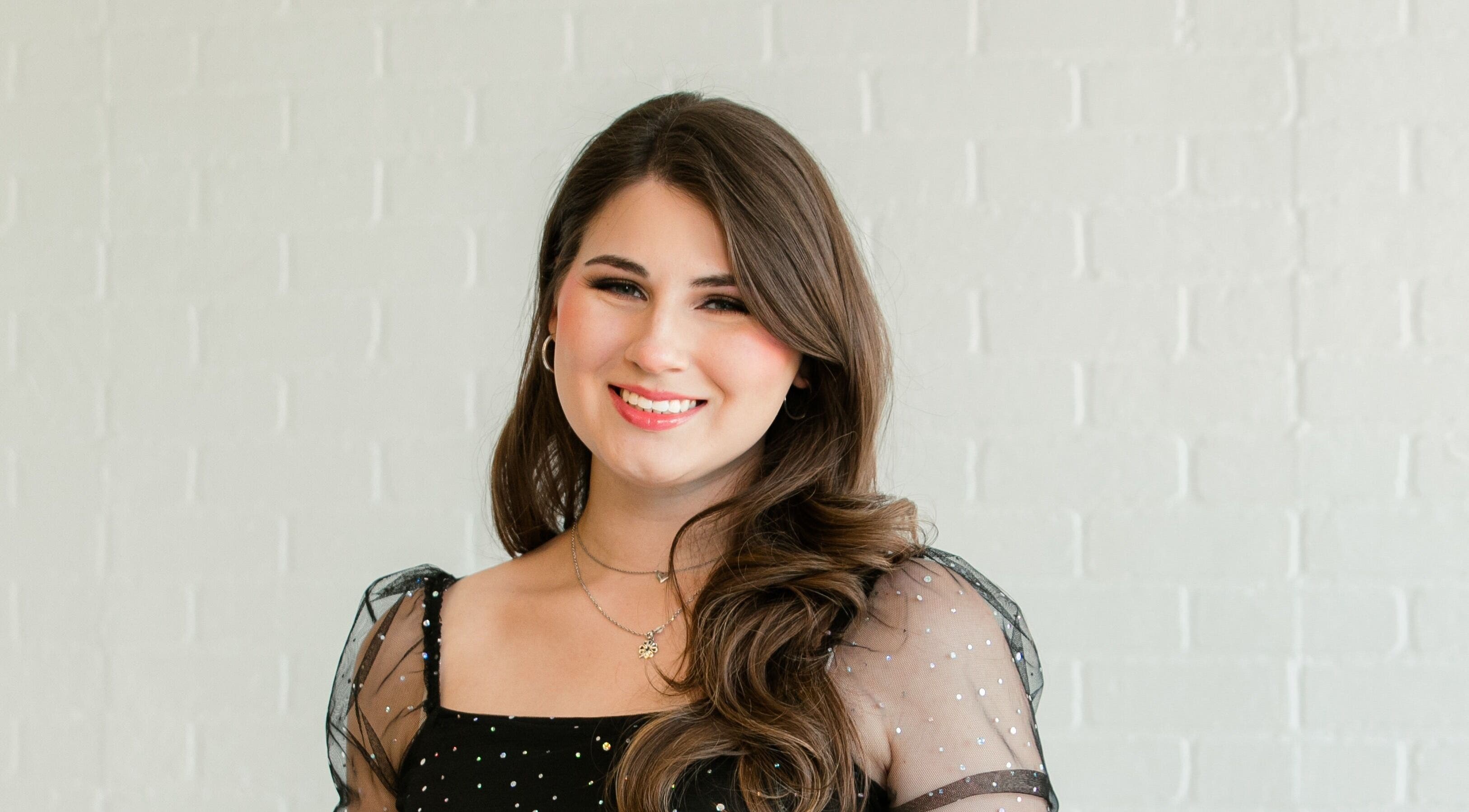 Smiling woman at Beauty by Kathryn, San Antonio, Texas, US, showcasing elegant hairstyle and makeup.