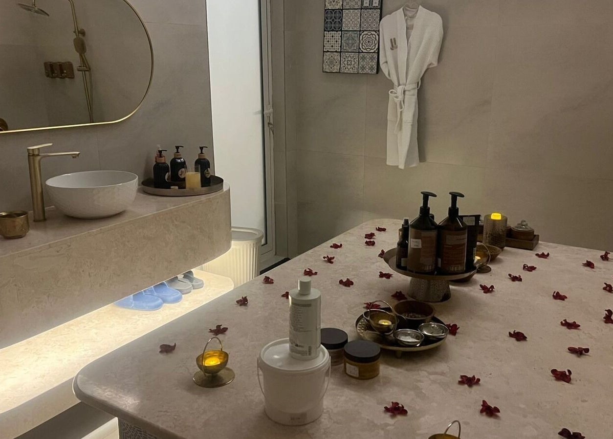 غرفة تدليك هادئة في Hanay Spa, الدمام, Eastern Province, SA مزينة بالشموع والزيوت العطرية.