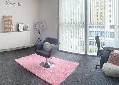 Dionoire salon interior featuring a cozy chair and pink rug in MILTON KEYNES, England, GB.