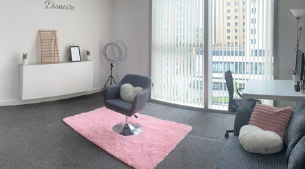 Dionoire salon interior featuring a cozy chair and pink rug in MILTON KEYNES, England, GB.