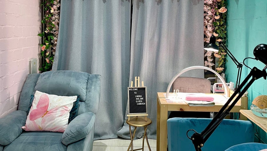 Cozy interior at Lindels Nail Bar, Cape Town, Western Cape, ZA with plush seating and elegant decor.