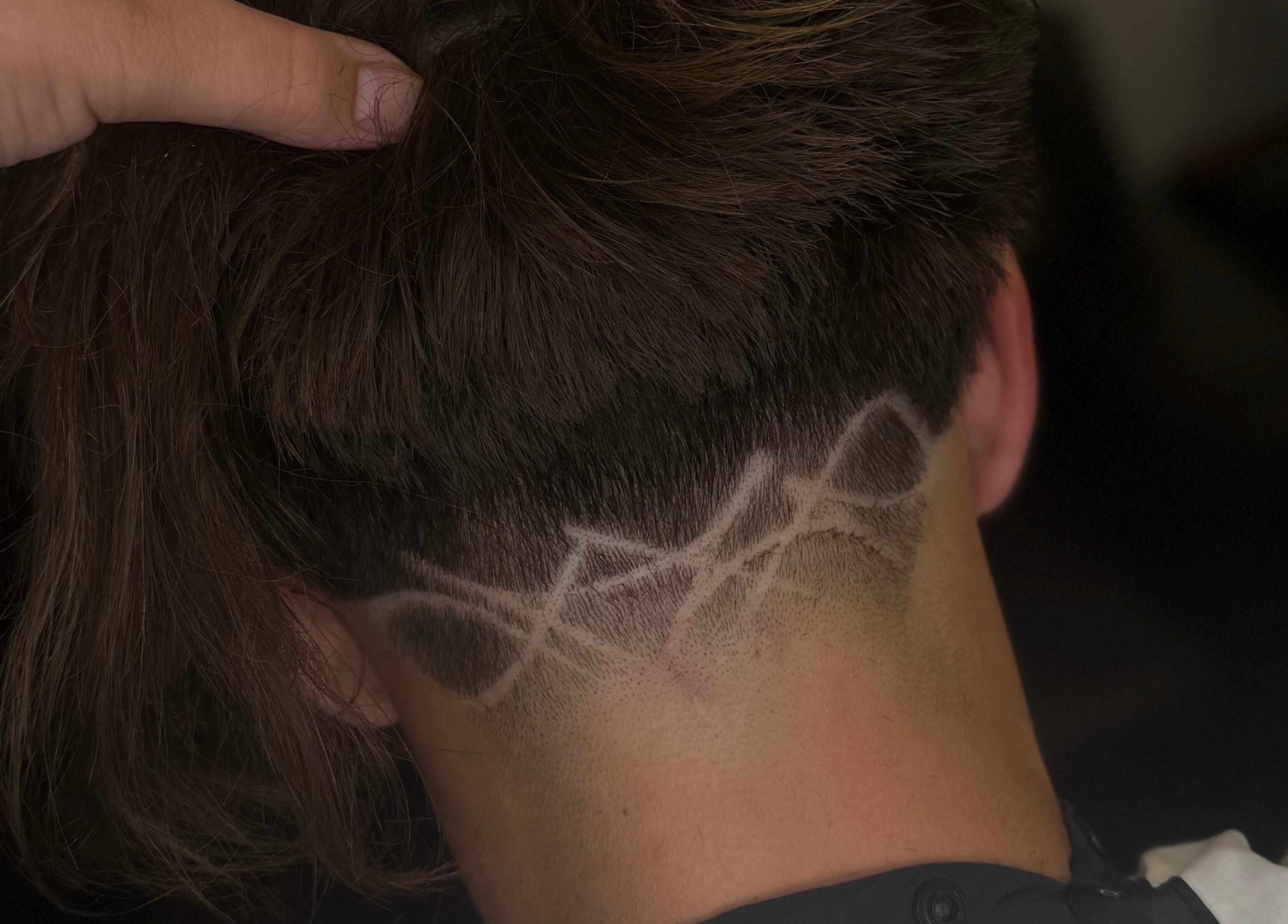 Intricate hair design at Barber Jake in Motueka, Tasman, NZ showcasing artistic fade technique.
