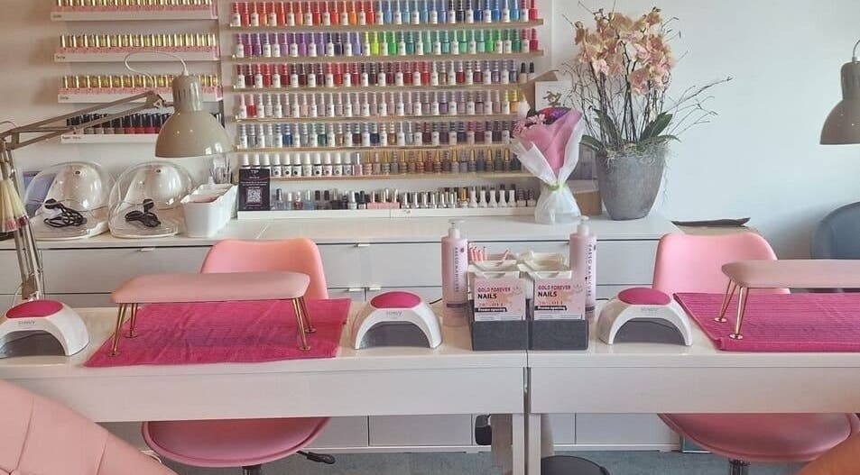 Chic manicure setup at Gold Forever Nails in Sandyford Dublin 18, showcasing a colorful polish wall.