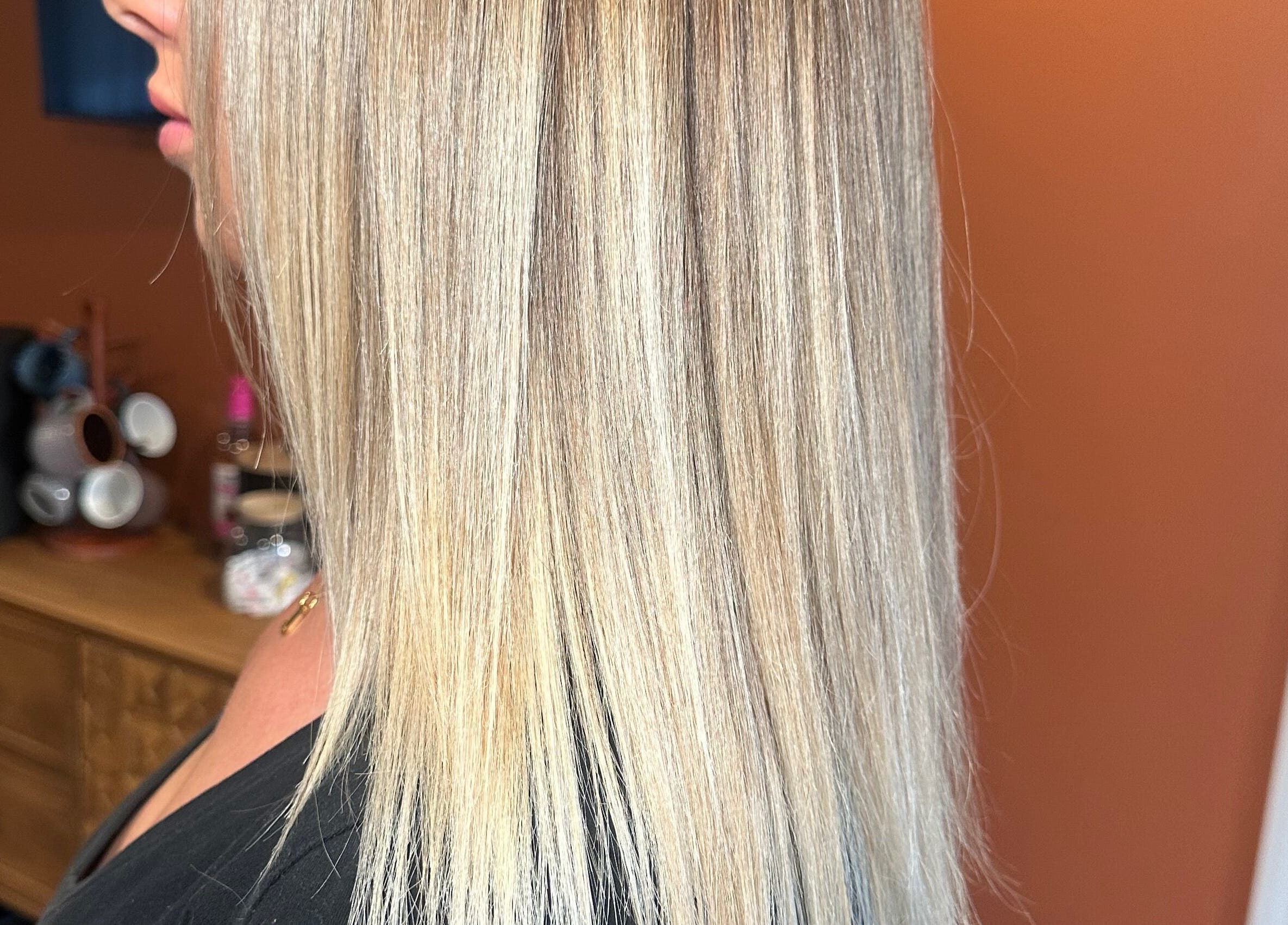 Sleek blonde hair styled at Heather Schreiber, Niagara Falls, New York, US, showcasing vibrant highlights.