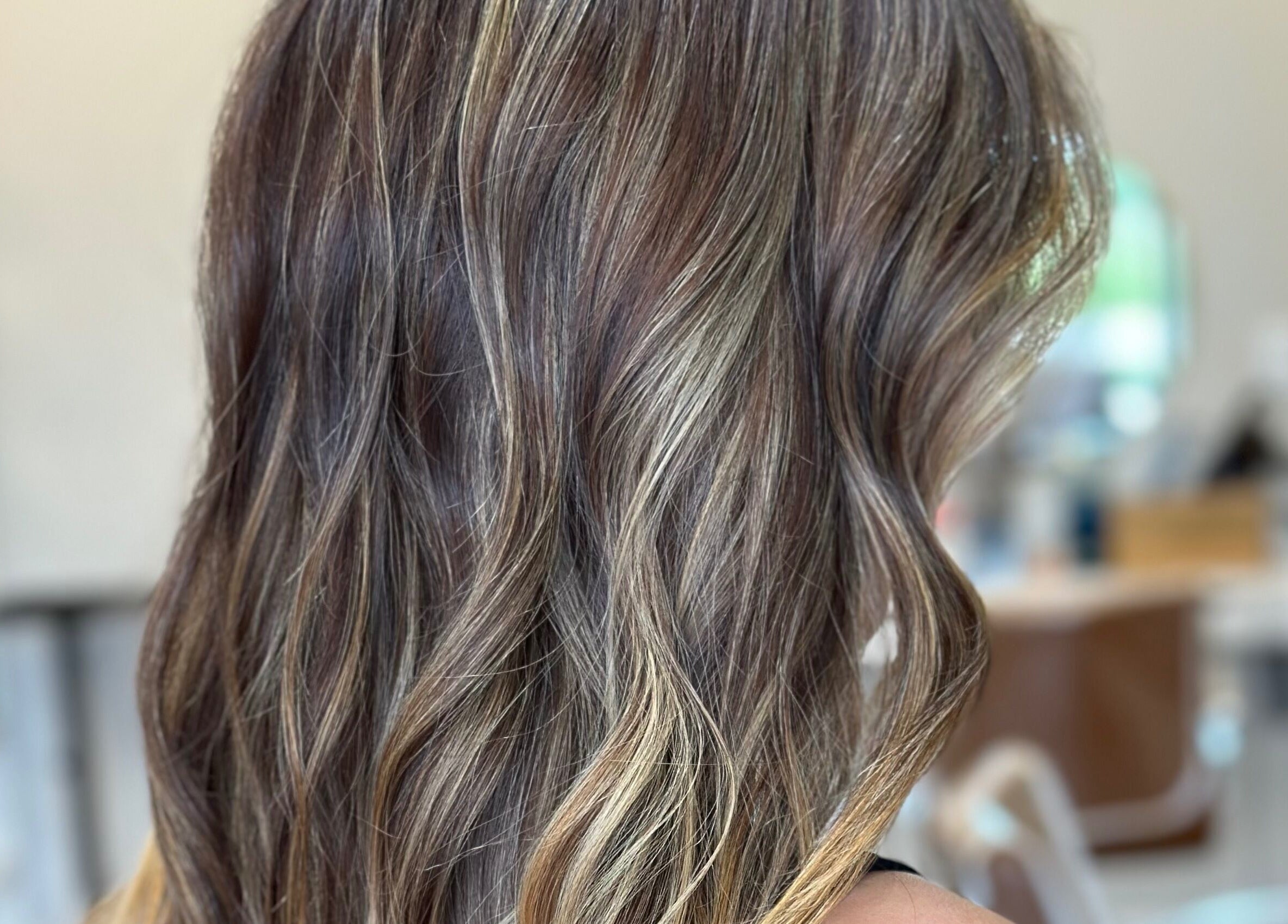 Stylish wavy hairstyle at Heather Schreiber, Niagara Falls, New York, US, showcasing vibrant highlights.