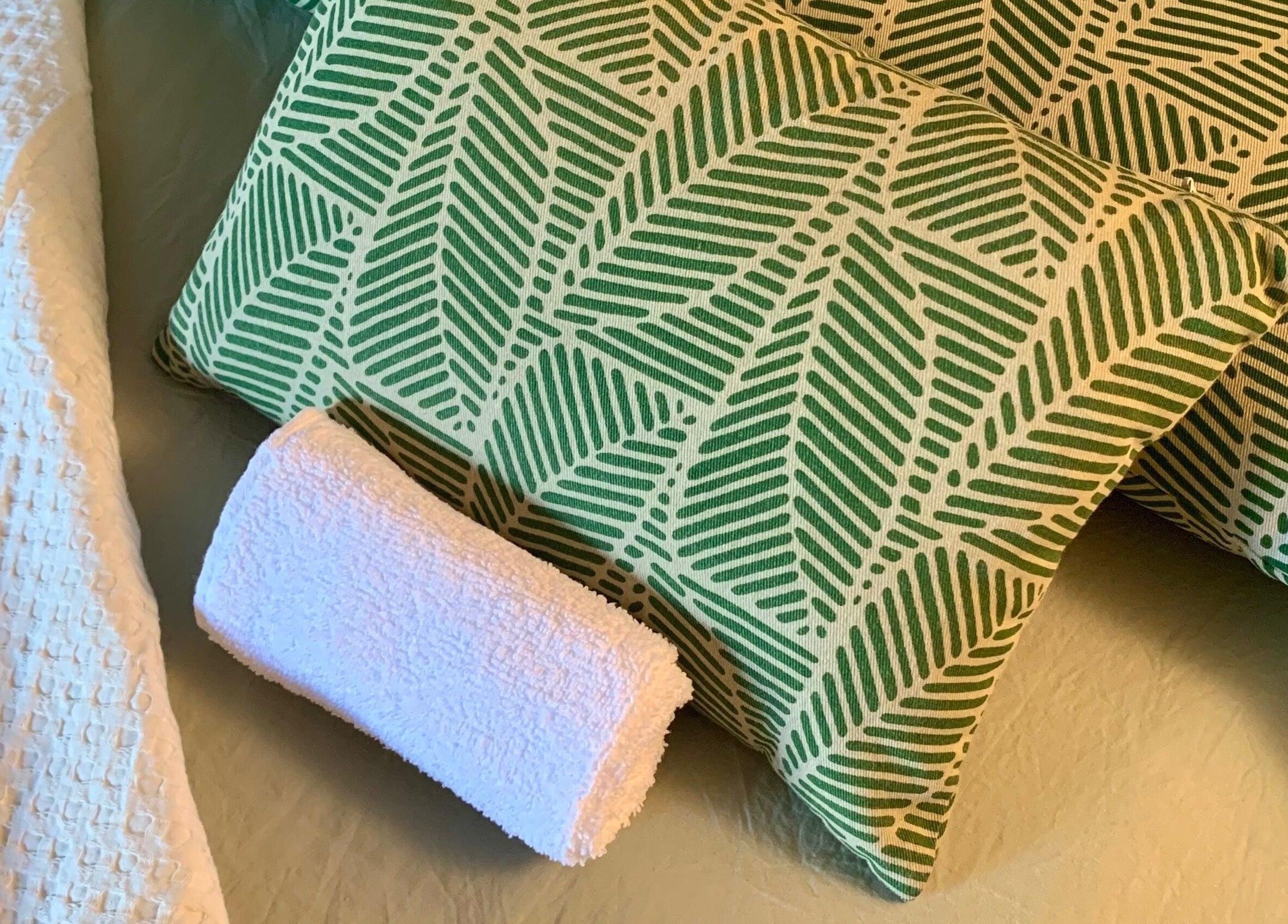 Coussins verts à motif feuille et serviette blanche à La cabine, Brive-la-Gaillarde, Nouvelle-Aquitaine, FR.