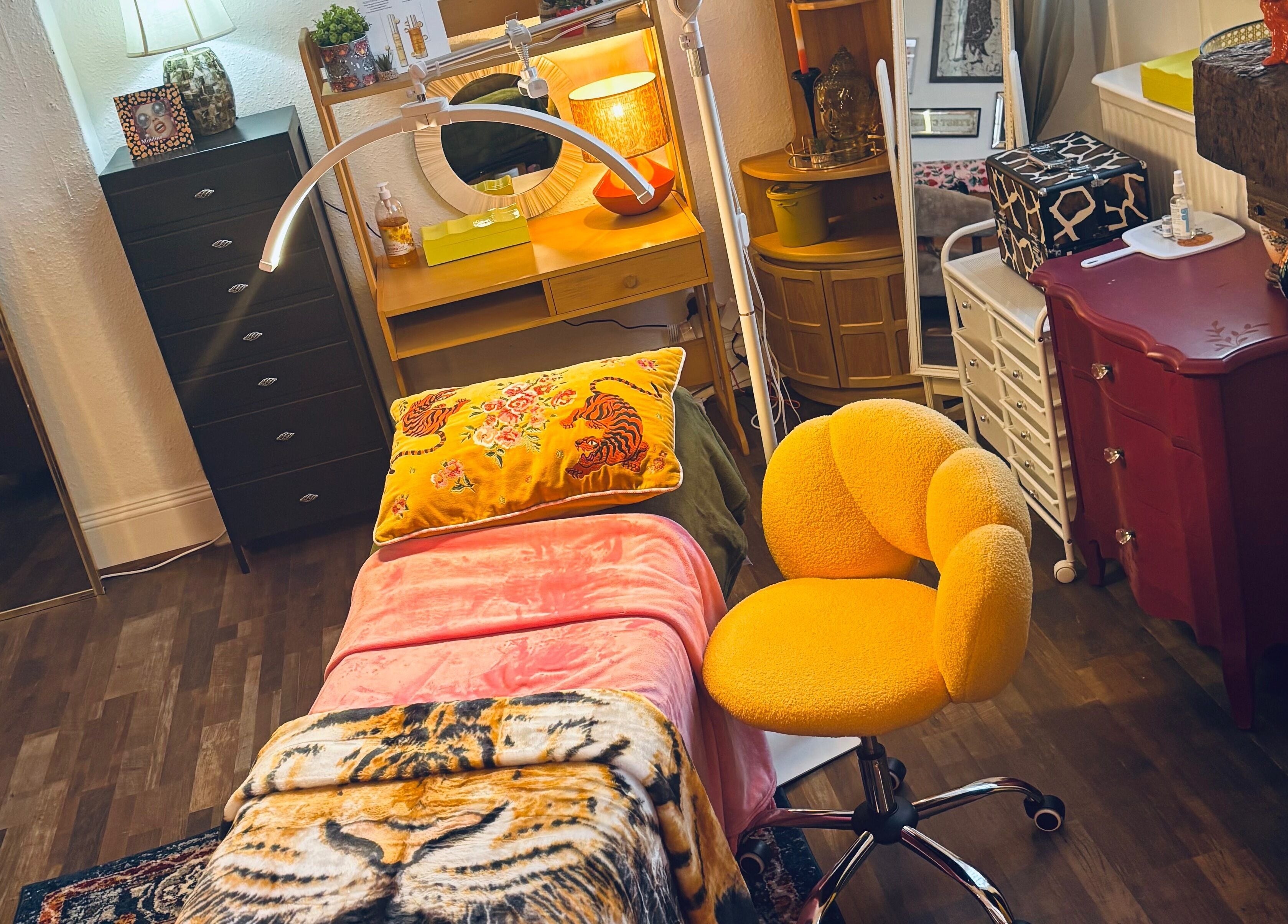 Cozy treatment room at Iris Medical Aesthetics, Cheltenham, England, GB with vibrant decor and comfy seating.