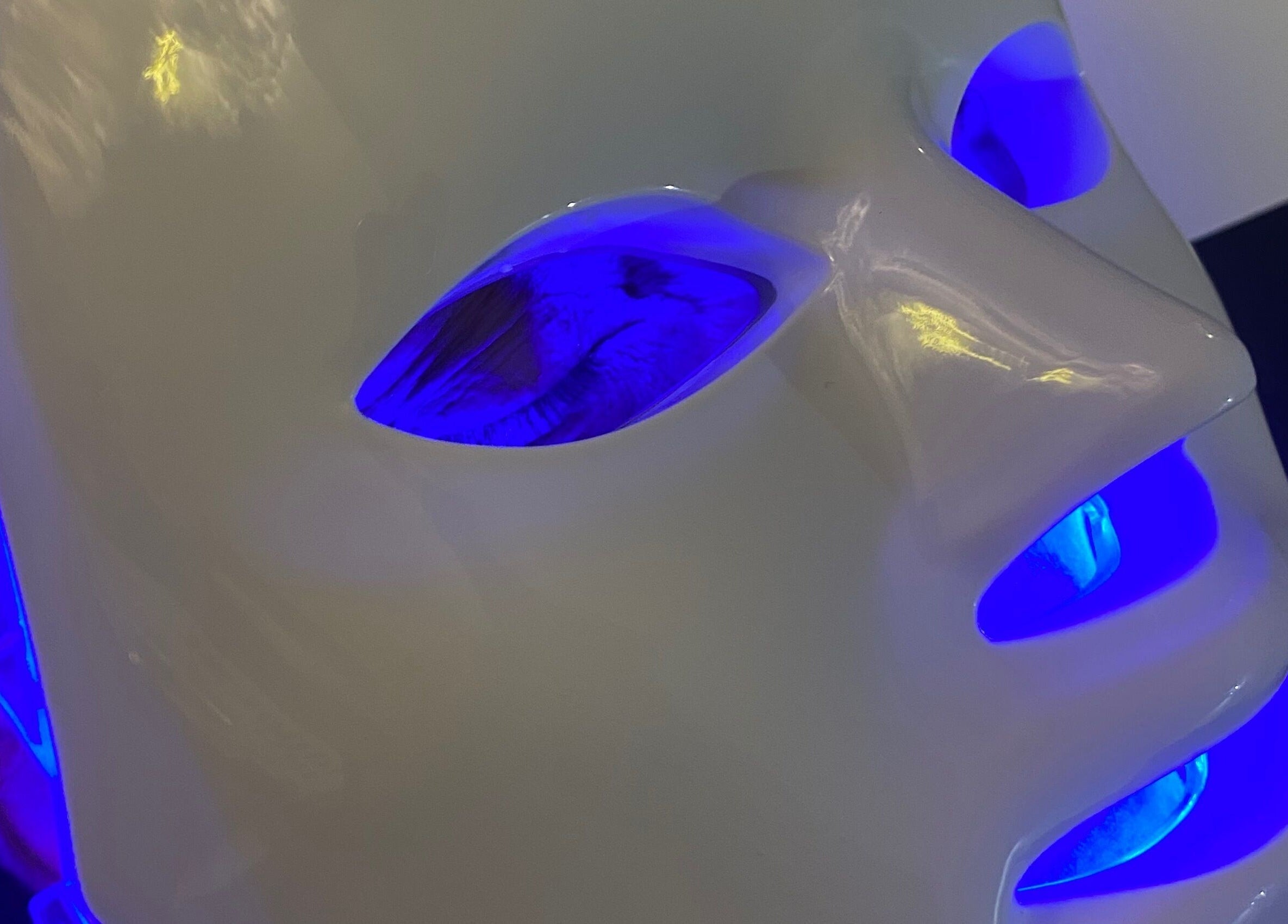 LED facial mask glowing blue at Byciaralouise, Oswaldtwistle, England, GB for skincare treatment.
