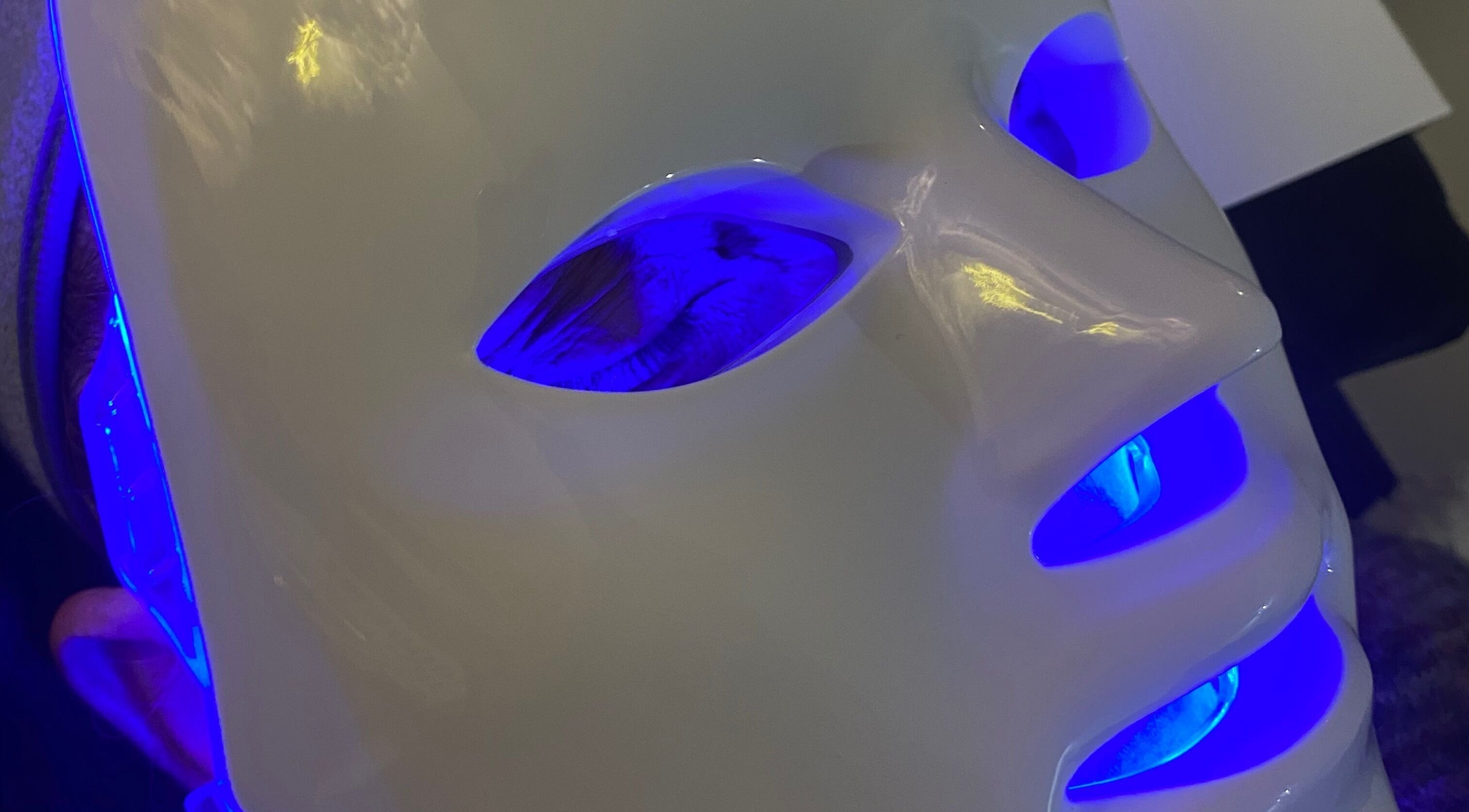 LED facial mask glowing blue at Byciaralouise, Oswaldtwistle, England, GB for skincare treatment.