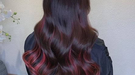 Elegant wavy hairstyle with red highlights at Finesse Beauty & Hair Salon, Newcastle upon Tyne, England, GB.