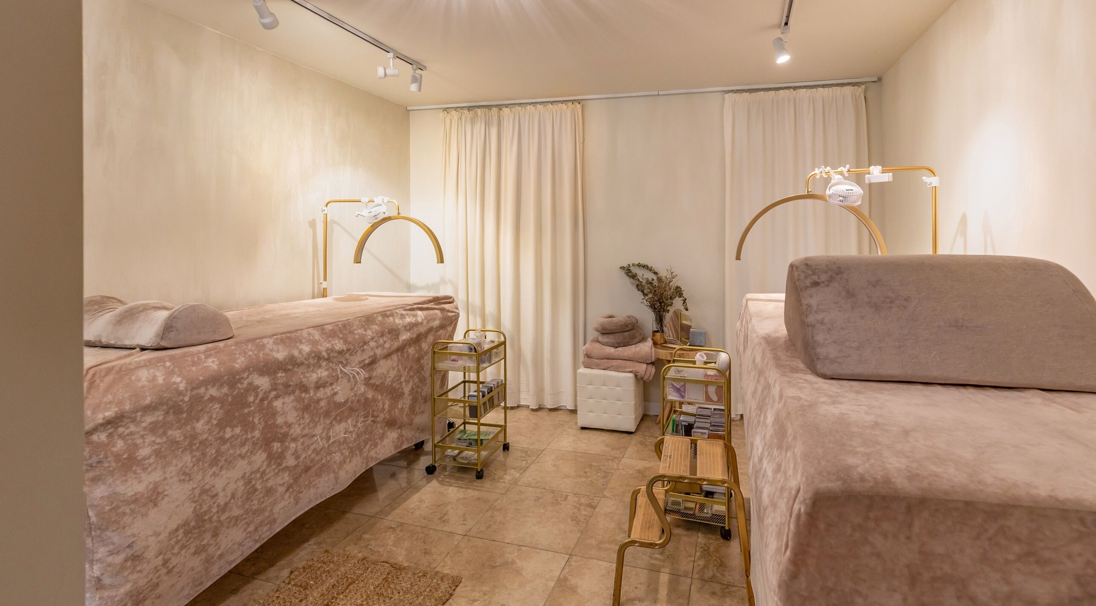 Elegant spa room at Velvet Beauty Studio, New York, New York, US with plush massage beds and soft lighting.