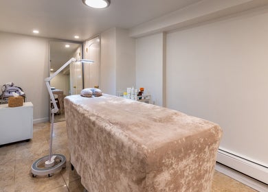 Serene spa room at Velvet Beauty Studio, New York, New York, US, featuring a plush treatment bed and soft lighting.