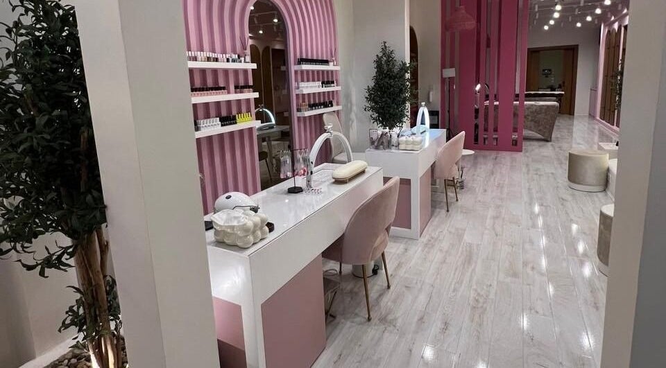 Stylish beauty salon interior at Dumo, جدة, مكة المكرمة, SA, featuring elegant pink decor and nail stations.