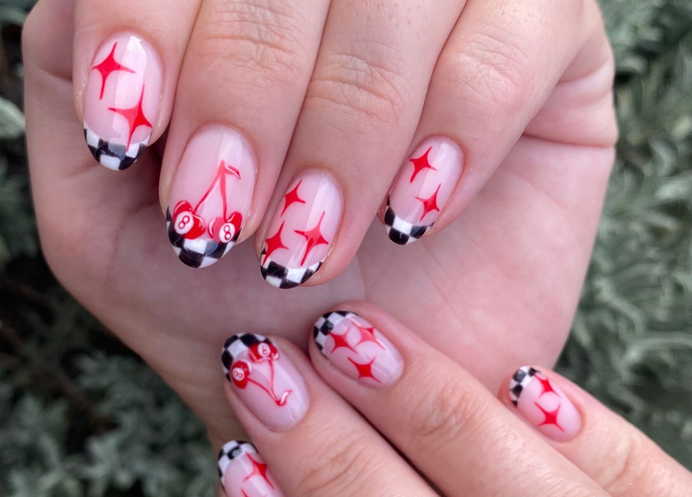 Stylish manicure with cherry and checkered design at Complete Nails by Kristie, Lethabong, Gauteng, ZA.