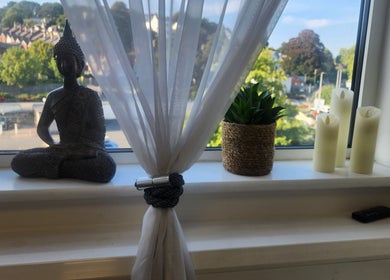 Tranquil windowsill at Kintsugi Beauty & Holistics, Newton Abbot, England, GB, featuring a Buddha statue and candles.